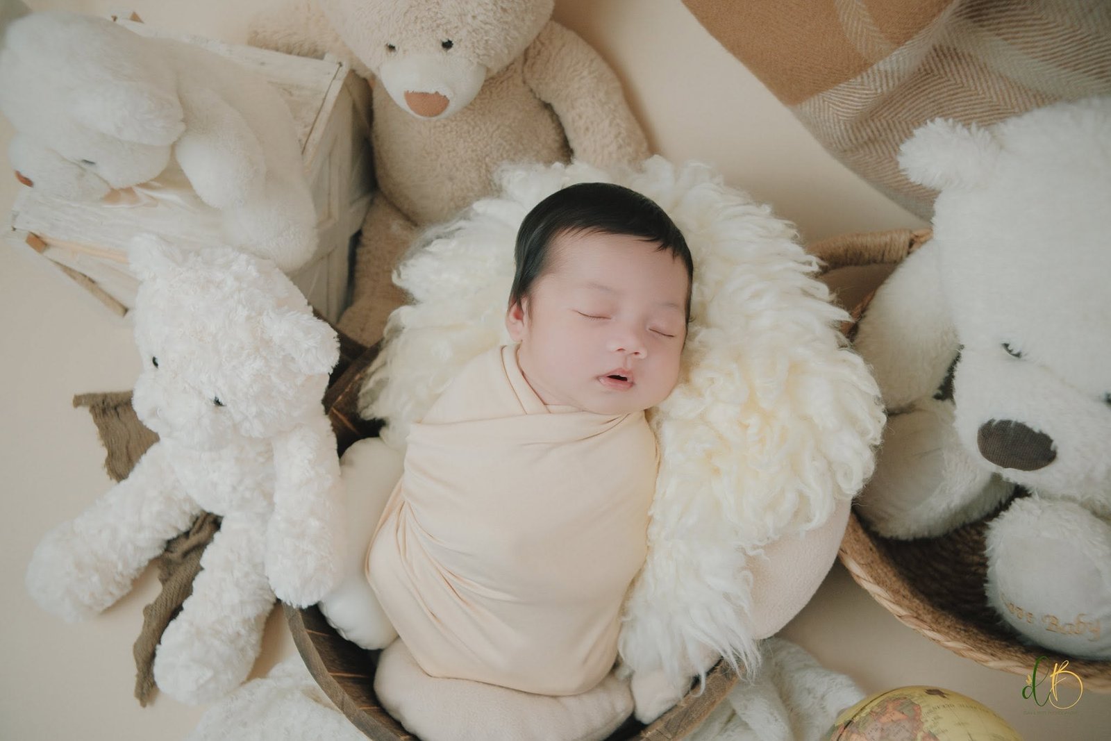 Newborn surrounded by soft teddy bears